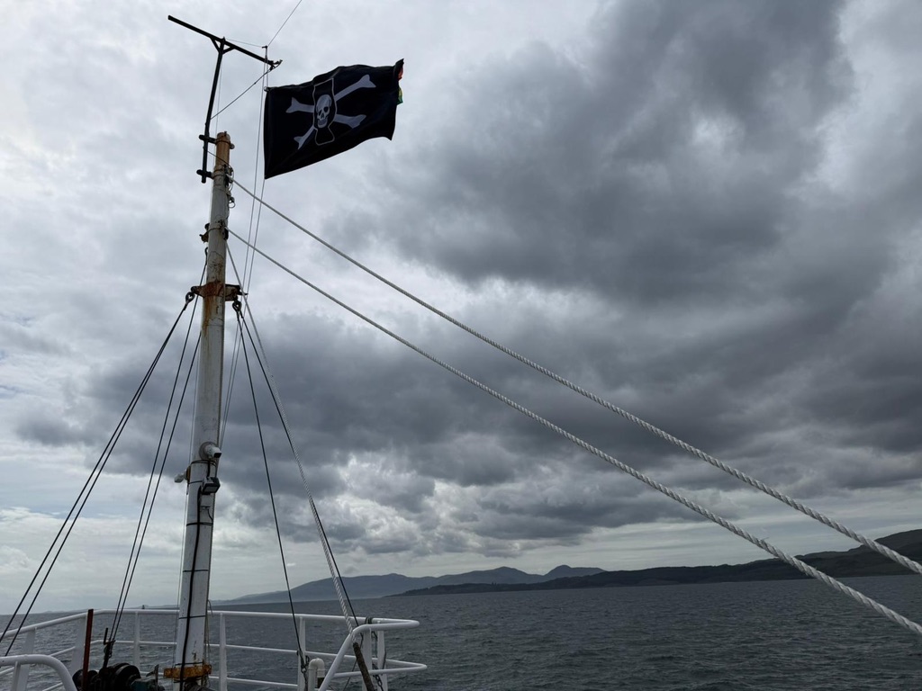 The Jolly Roger flying from the MV Honeydew
